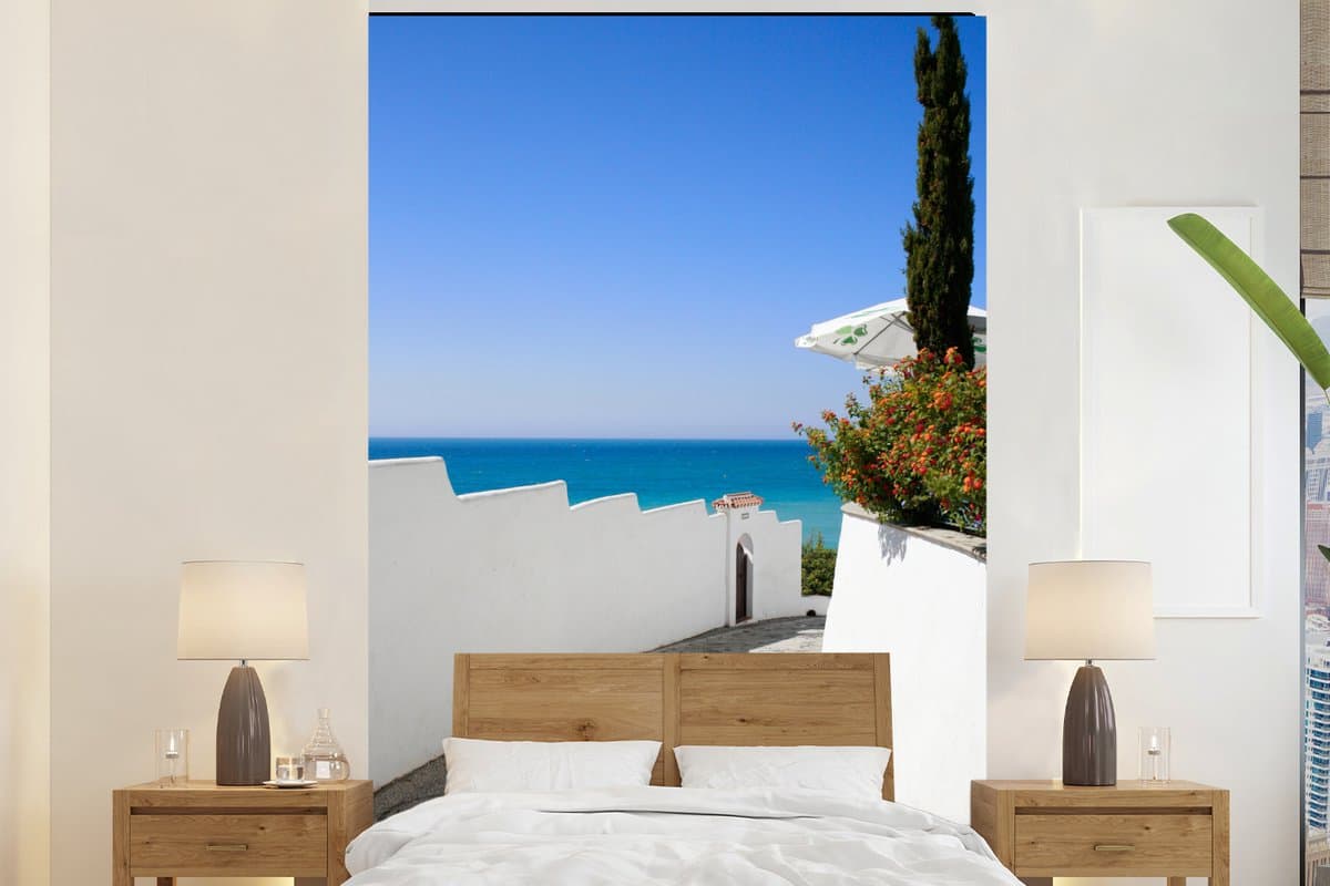 Behang - Fotobehang Een Spaanse straat met uitzicht op de zee - Breedte 225 cm x hoogte 350 cm